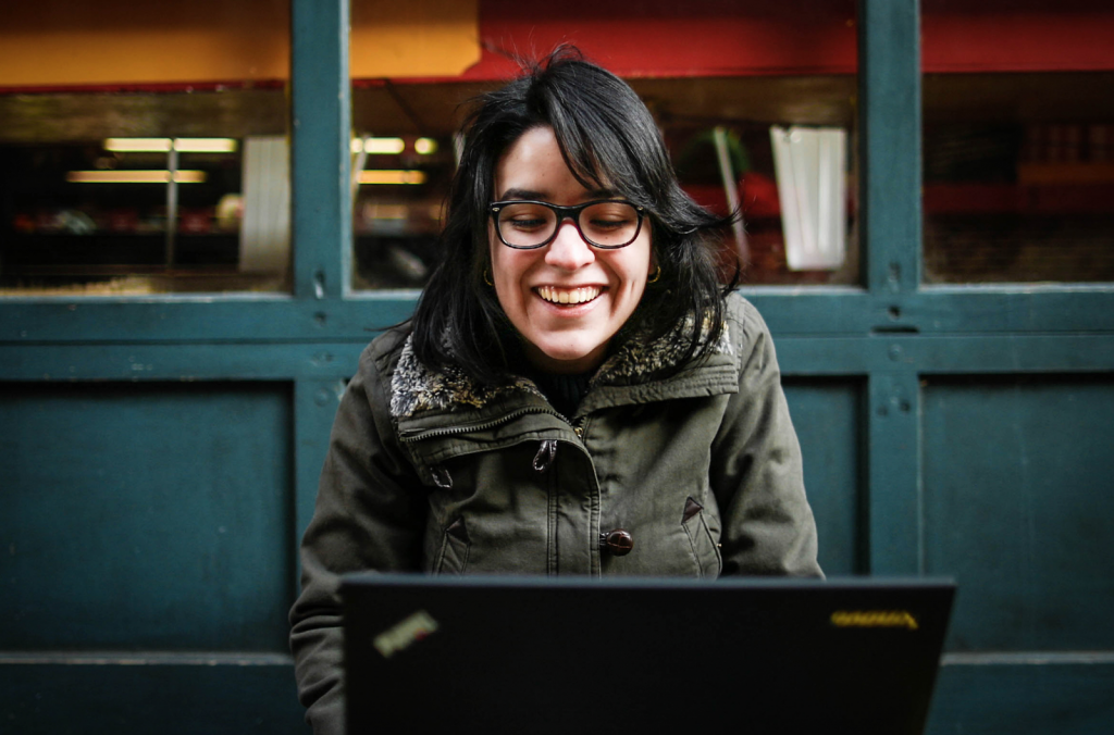 Gandica smiles while looking down at her laptop